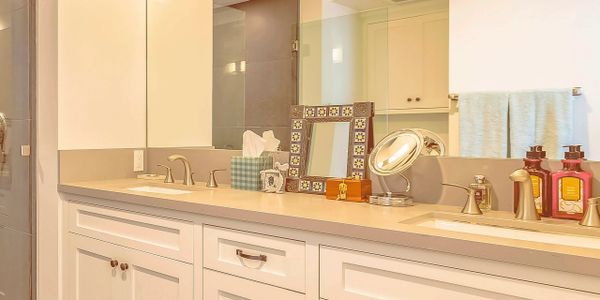 Modern bathroom vanity with dual sinks and large mirror.