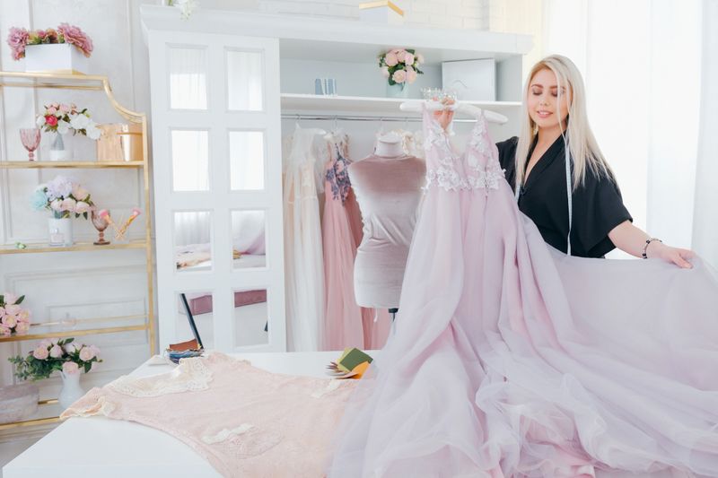 A beautifully designed customizable gown displayed elegantly on a mannequin, surrounded by colorful fabric swatches.