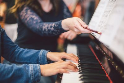 piano teacher pointing out notes on the score to student