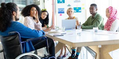 Diverse team having a meeting around a table in a bright office.