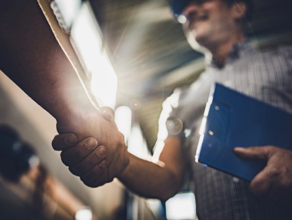 Two people shaking hands in a professional setting.