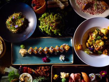 Elegant Asian fusion dinner spread with sushi rolls, edamame, sashimi, and gourmet small plates.