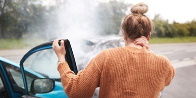 A lady grasping her neck follow a motor vehicle accident, representing musculoskeletal injury 