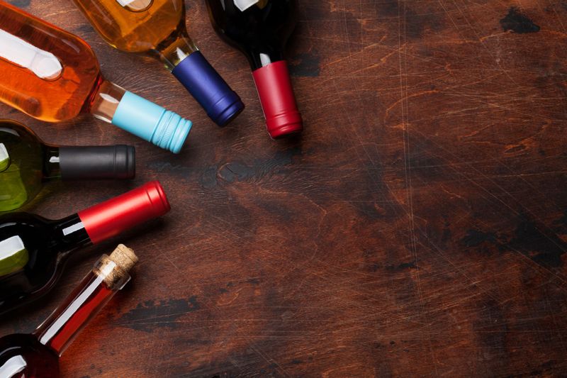 Various wine bottles on wooden table. Red, rose and white wines. Top view flat lay with copy space for your text