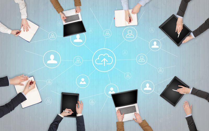 Group of people with devices in hands working in team on tablets, laptops with office, connection, cloud concept