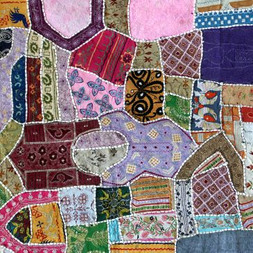 Colorful patchwork quilt with various fabric patterns.