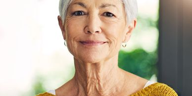 Portrait of a smiling elderly woman with short gray hair.