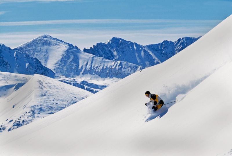 Snow Skier Skiing in Untracked Snow with Mountain View