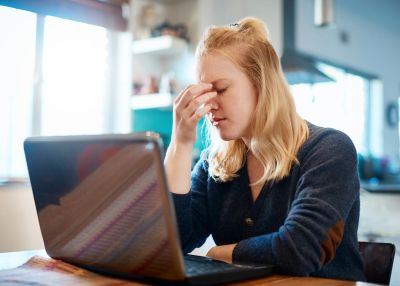 Woman stressed while using her laptop.