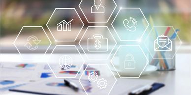 Business icons overlaying a blurred office desk with documents and stationery.