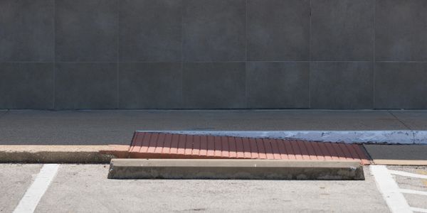 Empty handicapped parking space with reserved sign and ramp.