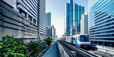 Bangkok skytrain going between buildings in the city.