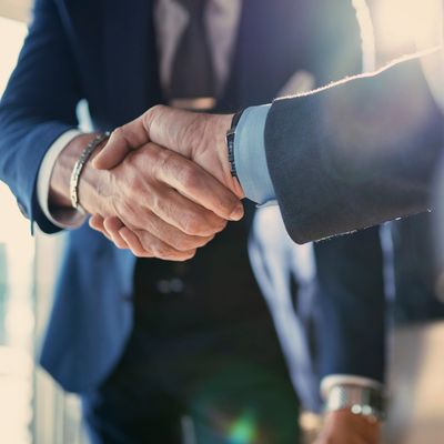 Two businessmen shaking hands in a professional setting.