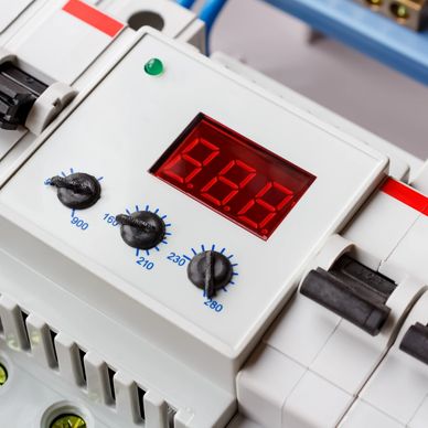 Close-up of an electronic circuit breaker with dials and a digital display.