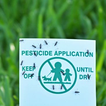 Sign warning of pesticide application with insects on it.