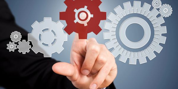 Hand in suit interacting with digital gears, highlighting one red gear.