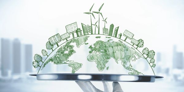 Hand holding a tray with a green energy-themed Earth illustration.