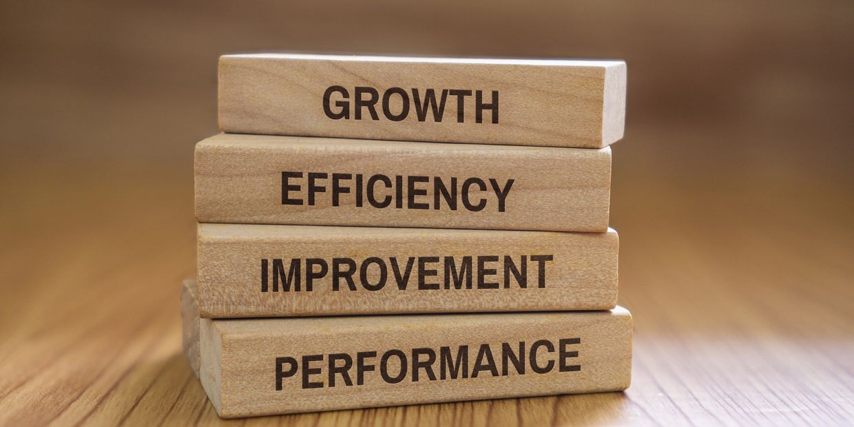 Stacked wooden blocks with words growth, efficiency, improvement, and performance.
