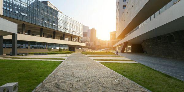 Walkway between modern buildings at sunset.