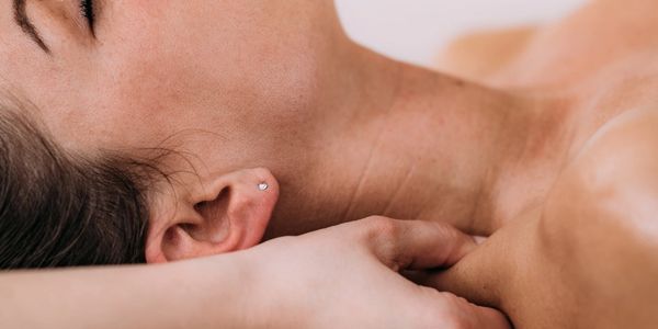 Woman receiving a relaxing neck massage with closed eyes.