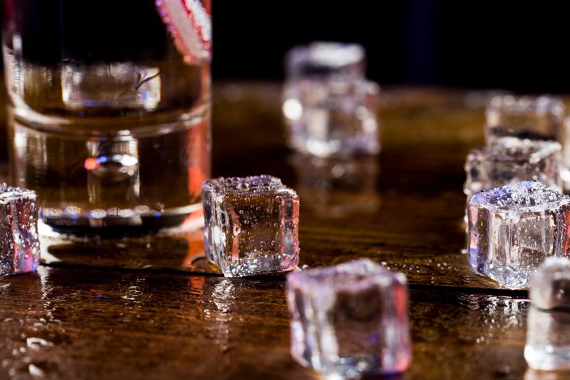 Melting ice cubes with droplets of water on a wooden background