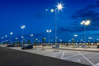 A brightly lit, mostly empty parking lot at dusk.
Electrical pole parking lot.