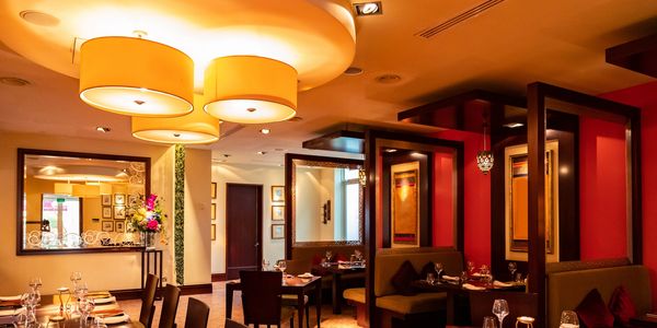 Cozy restaurant interior with warm lighting and elegant table settings.
