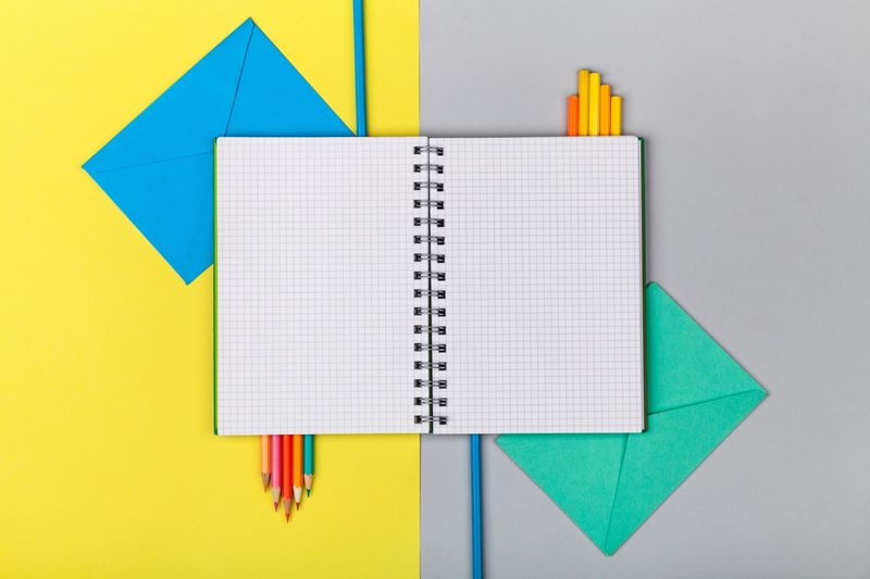 School and office supplies on tablet above alarm clock arranged back backdrop background
