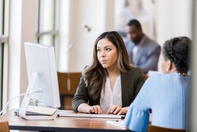 Businesswoman discussing work at a computer.