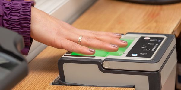 A hand scanning fingerprints on a biometric device.