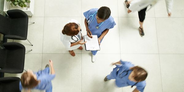 Medical staff discussing patient information in a busy hospital corridor.