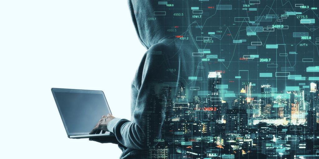 Hacker with laptop and city data overlay.