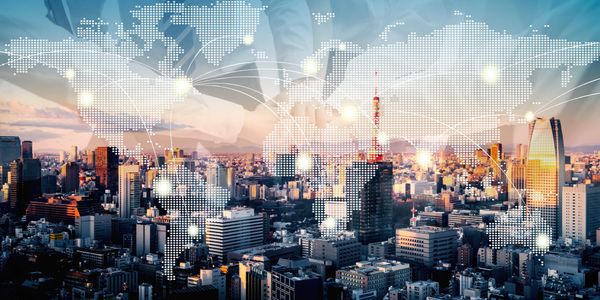 Cityscape with digital world map overlay representing global connectivity.