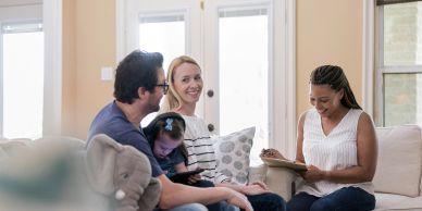 A family consults with a professional in a cozy living room.