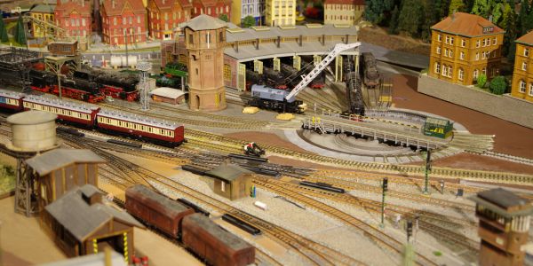 Detailed model train set with tracks, buildings, and trains in a miniature town.