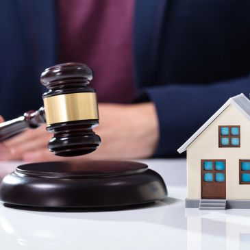 Judge's gavel and miniature house on table