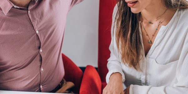 Two people discussing a floor plan at a table.