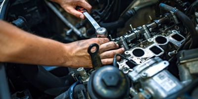 Hands using a wrench to repair a car engine. Engine Repair, Tune up, Electrical System Repair