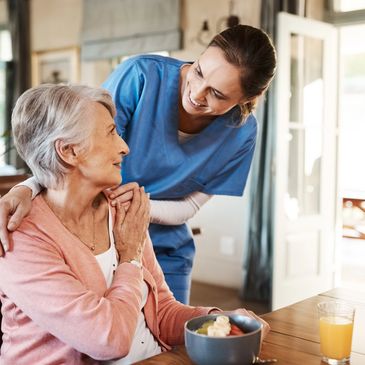 Caregiver assisting a senior woman with meal preparation