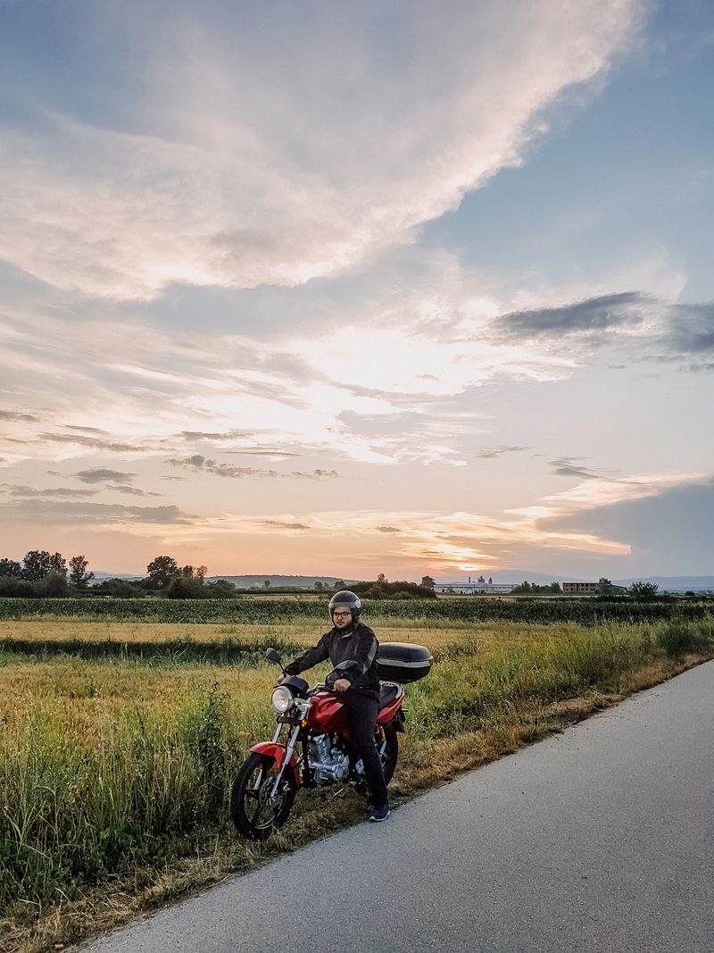 Biker man driving on motorbike on countryside road