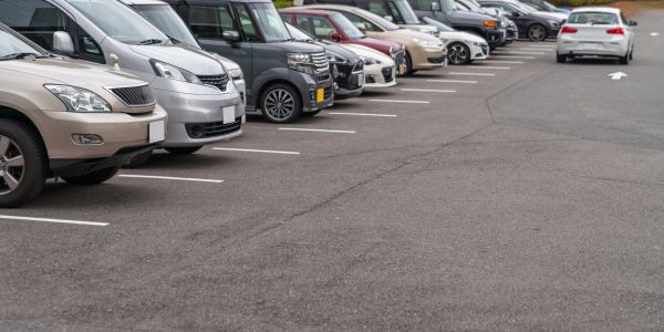 A row of parked cars in an outdoor parking lot.