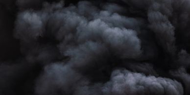 Thick black smoke with intense red flames rising from a fire.