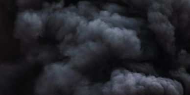 Thick black smoke with intense red flames rising from a fire.