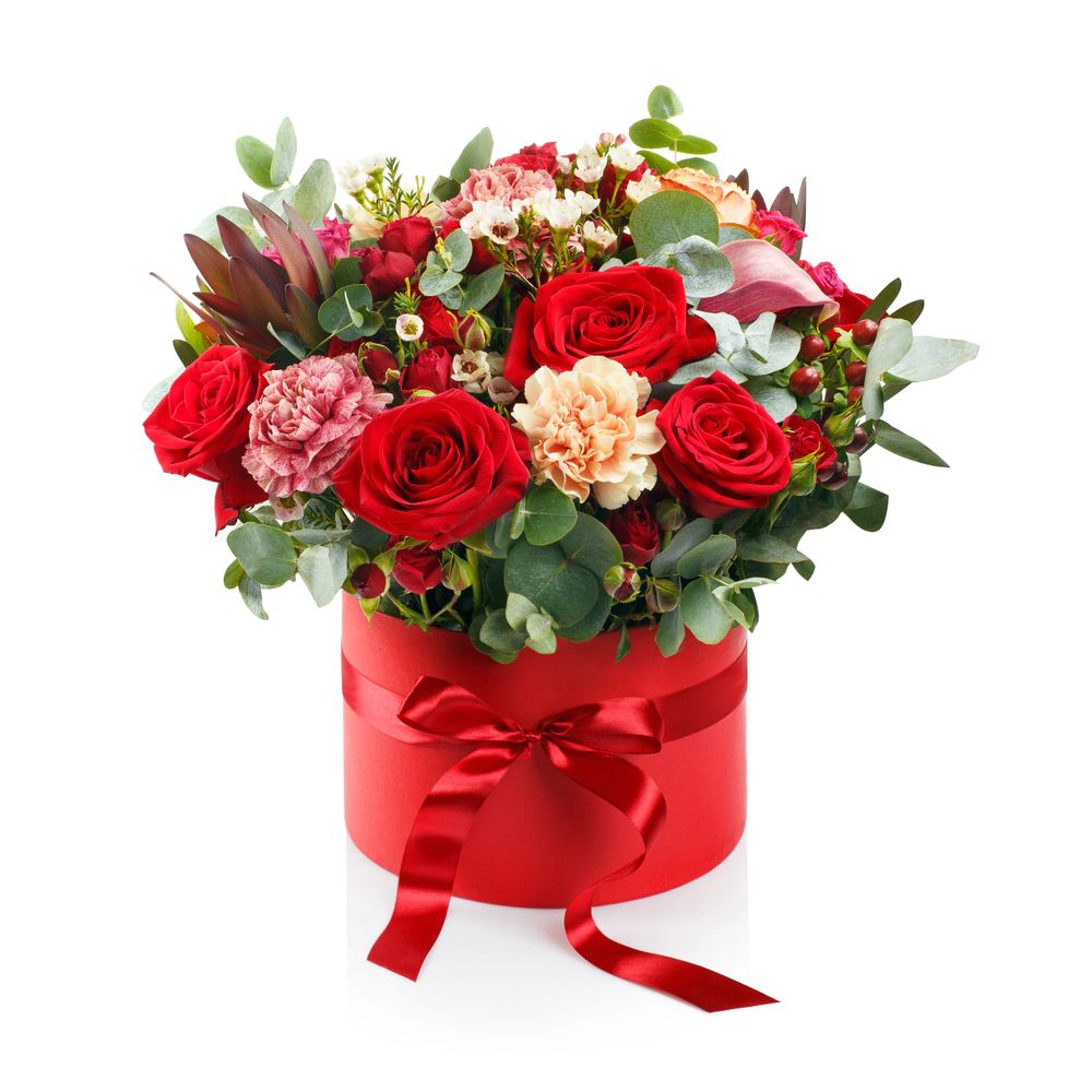 Elegant red and pink flower arrangement in a red hatbox with a satin bow.