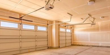 Empty, clean two-car garage with automatic doors and unfinished walls.