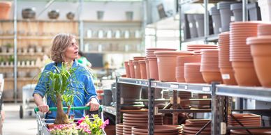 woman pushing a cart through a gardening center