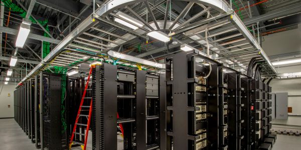 Interior of a modern data center with server racks and cables.