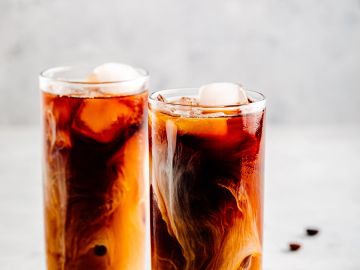 Two glasses of iced coffee with cream.