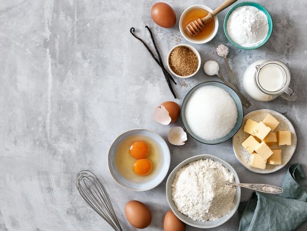 Baking ingredients including eggs, sugar, flour, butter, and vanilla beans.
