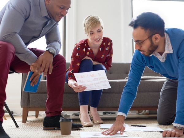 Three colleagues collaborating on a project in a casual office setting.